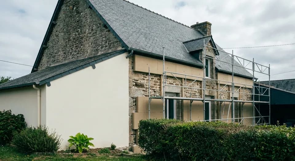 Maison bretonne en cours d'isolation par l'extérieur, panneaux isolants et enduit sous échafaudage